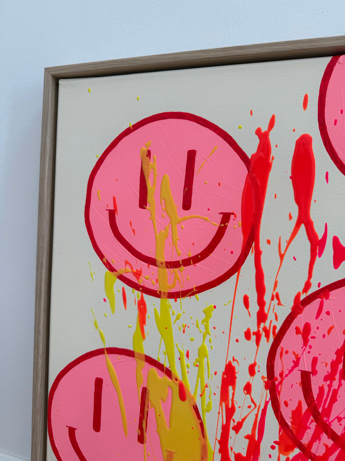 Oberer linker Bereich von HAPPY #32 mit pinkem Happy Face, satt kirschroter Kontur und zitronengelben Farbspritzern vor beigem Hintergrund.