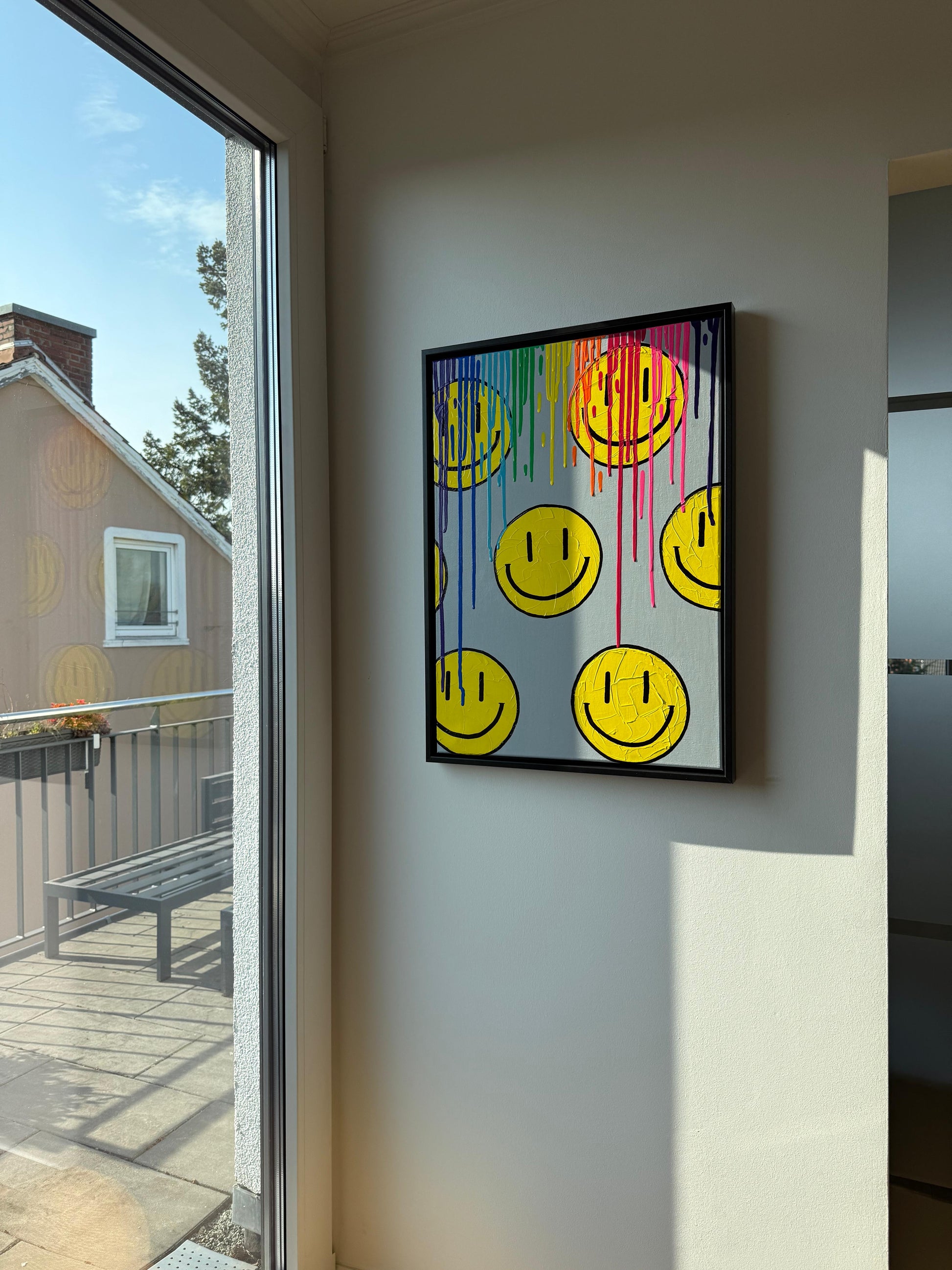 Abstraktes Happy Face Bild mit Regenbogen Farbverlauf im modernen Wohnraum, bunte Acrylkunst an heller Wand mit Blick zum Balkon, Dopamine Decor Wandkunst