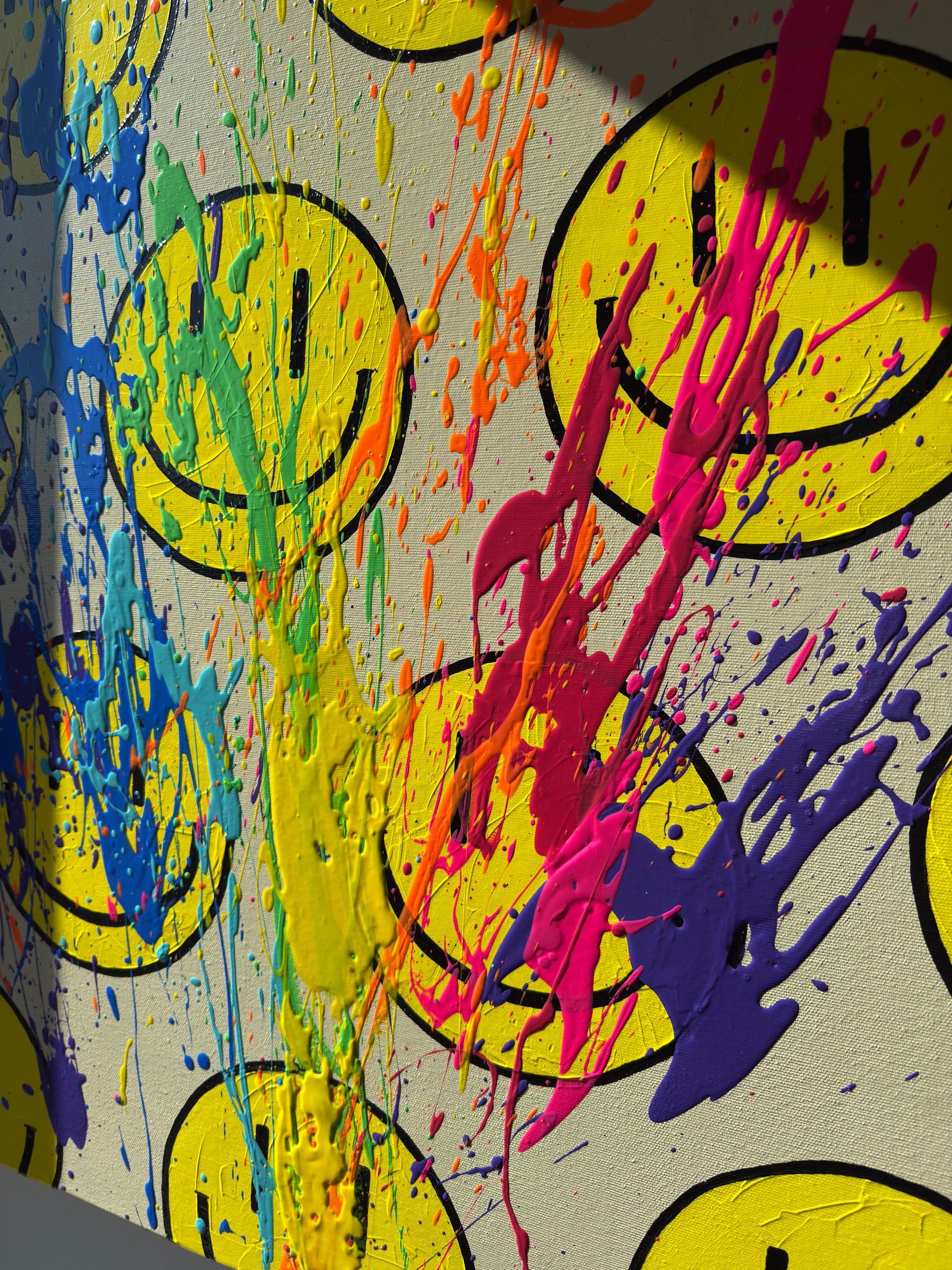 Abstrakte Farbspritzer in Gelb, Orange und Pink über Happy-Face-Motiv, moderne Kunst mit lebendiger Struktur und Bewegung