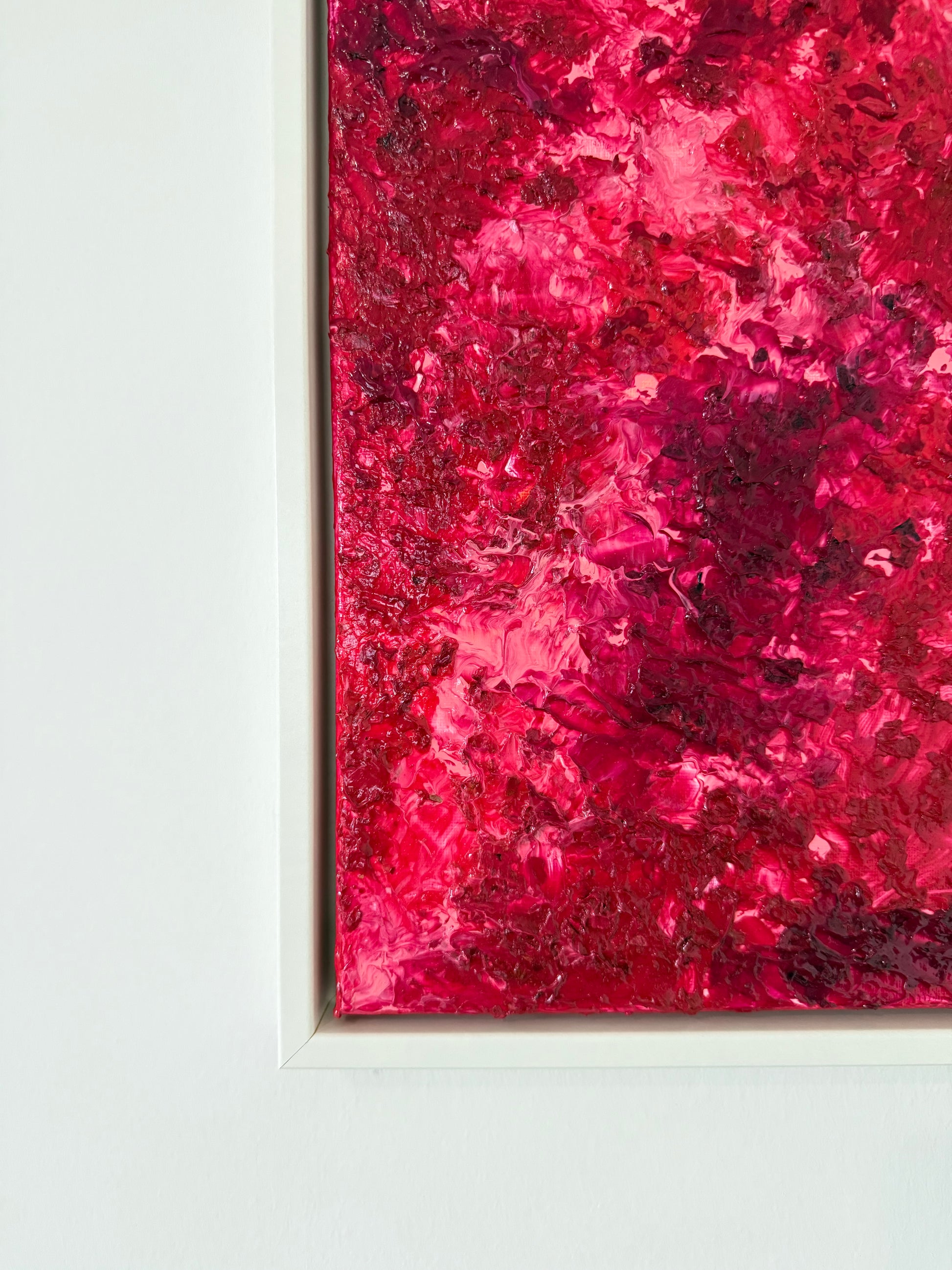 Ausschnitt der unteren Bildkante eines kleinen abstrakten Kunstwerks mit intensiver Farbwirkung, gezeigt im weißen Schattenfugenrahmen vor hellem Hintergrund.