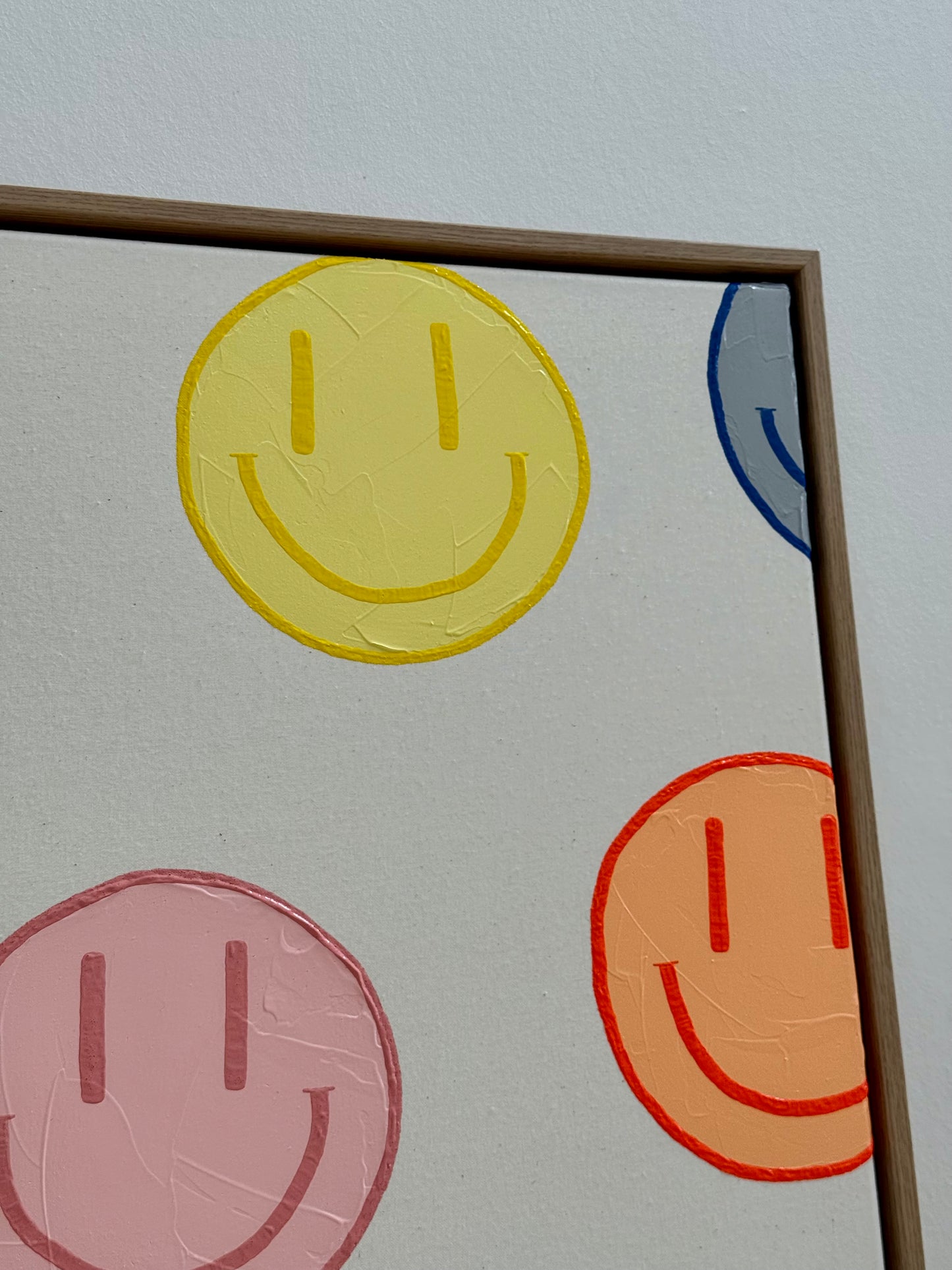 Detailansicht eines gelben Happy-Faces aus dem Originalkunstwerk HAPPY #19 mit feiner Struktur und Naturleinwand.