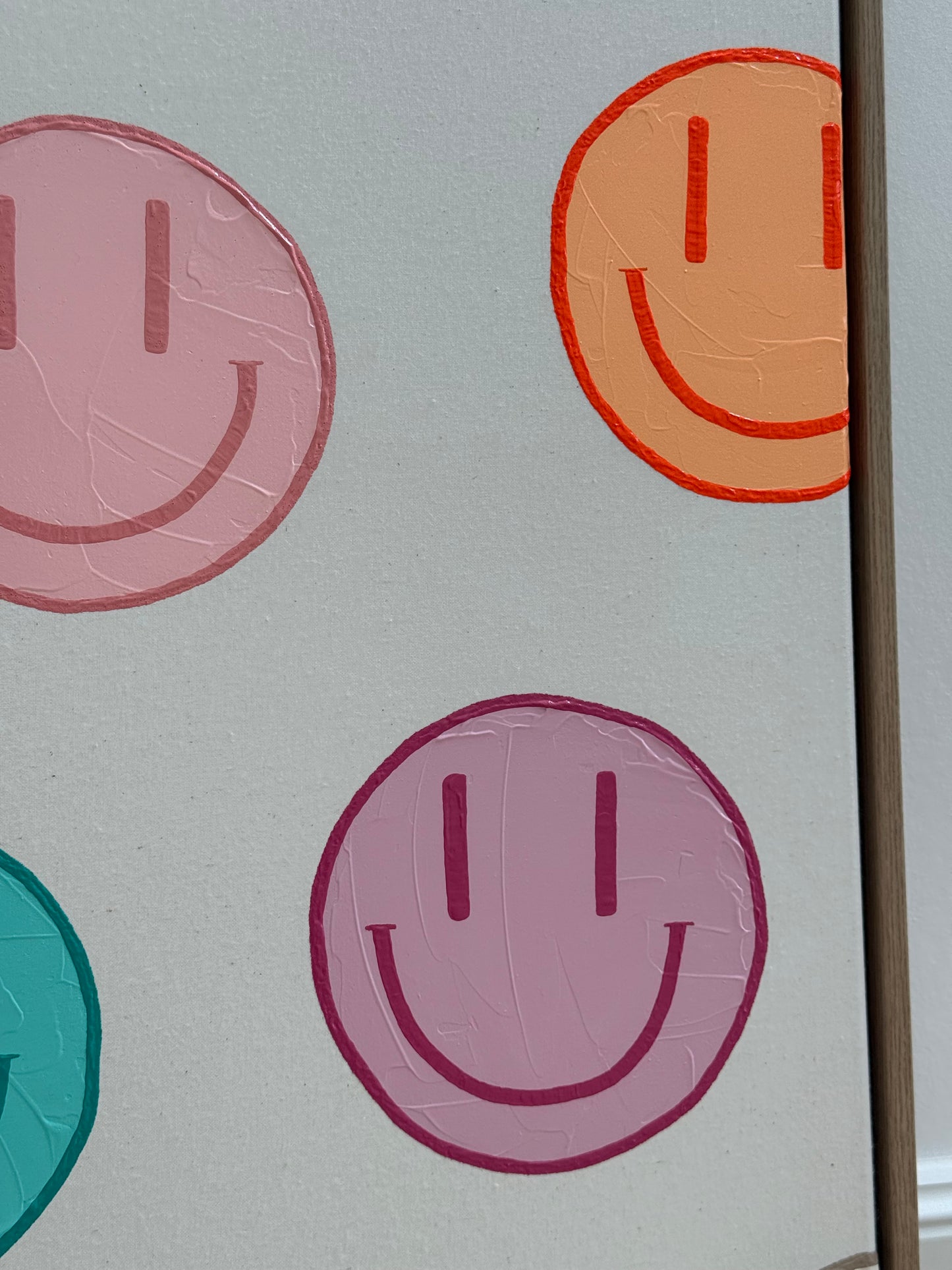 Detail von HAPPY #19 mit rosa- und apricotfarbenen Happy-Faces auf heller Naturleinwand und feiner Oberflächenstruktur.