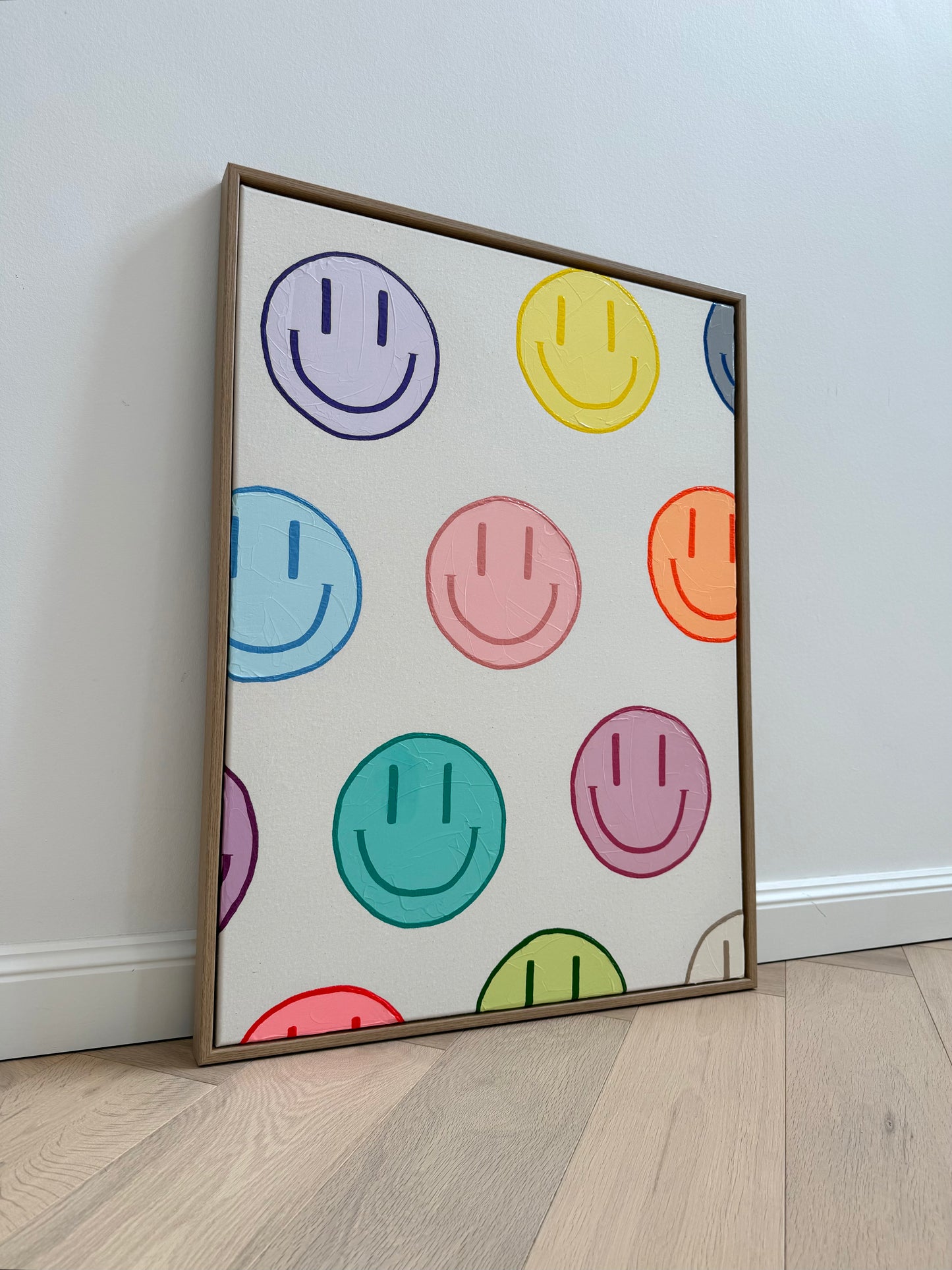 Originales Acrylbild HAPPY #19 mit bunten Happy-Faces auf Naturleinwand und hochwertigem Holzrahmen in moderner Interior-Ansicht.