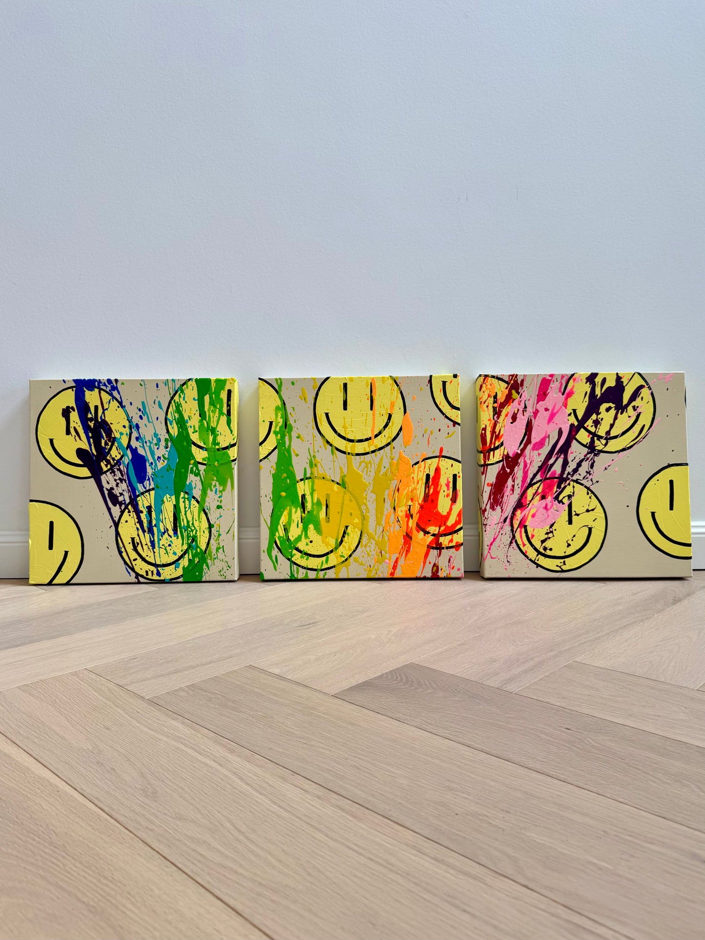 Drei moderne Happy-Face-Gemälde als zusammengehöriges Auftragskunstwerk mit kräftigen Neonfarben, Splash-Technik und abstrakter Acrylkunst auf Leinwand.