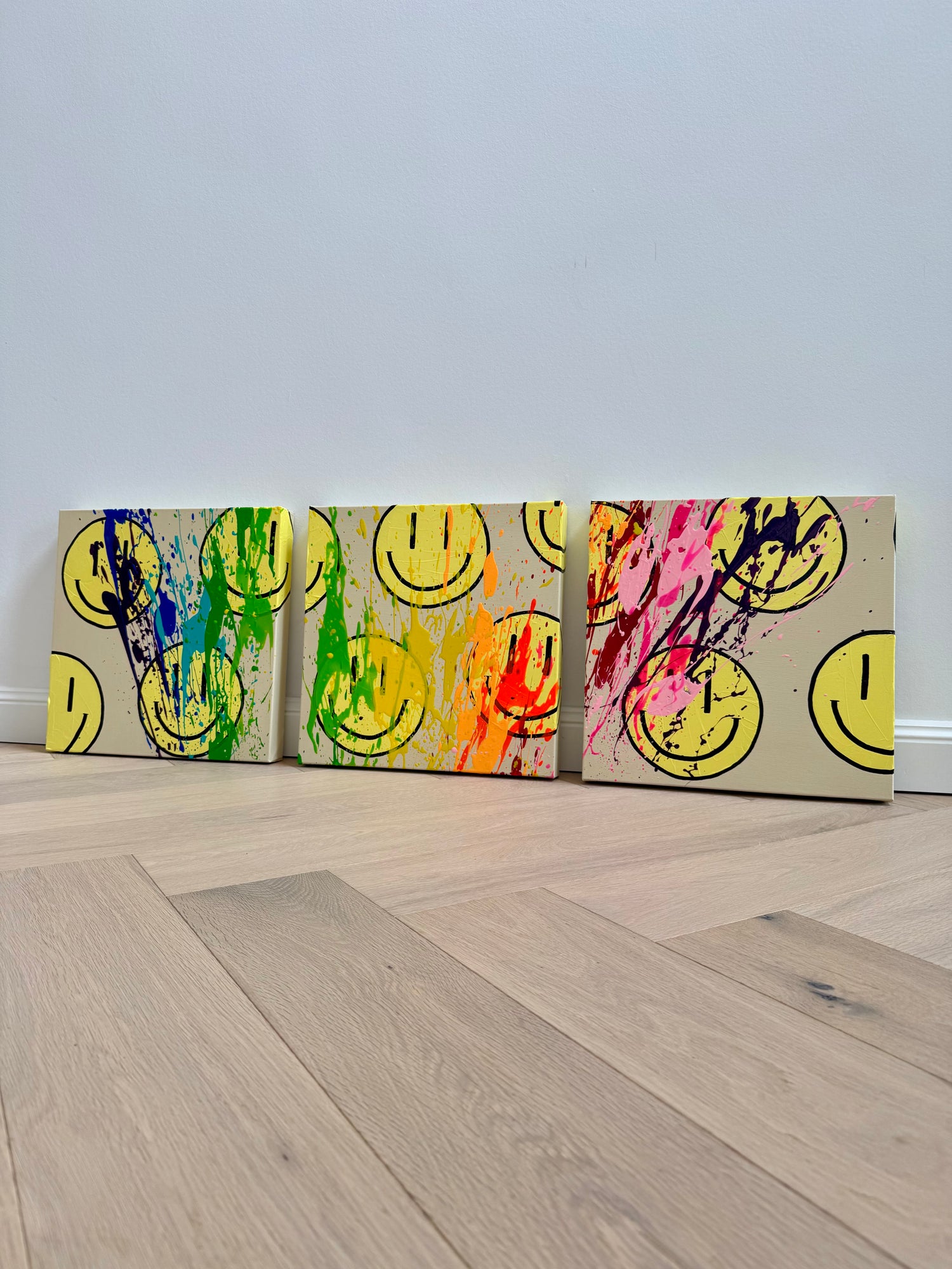 Moderne Pop-Art-inspirierte Happy-Face-Kunstwerke als farbenfrohes Acryl-Triptychon auf Leinwand mit ausdrucksstarken Neonakzenten.