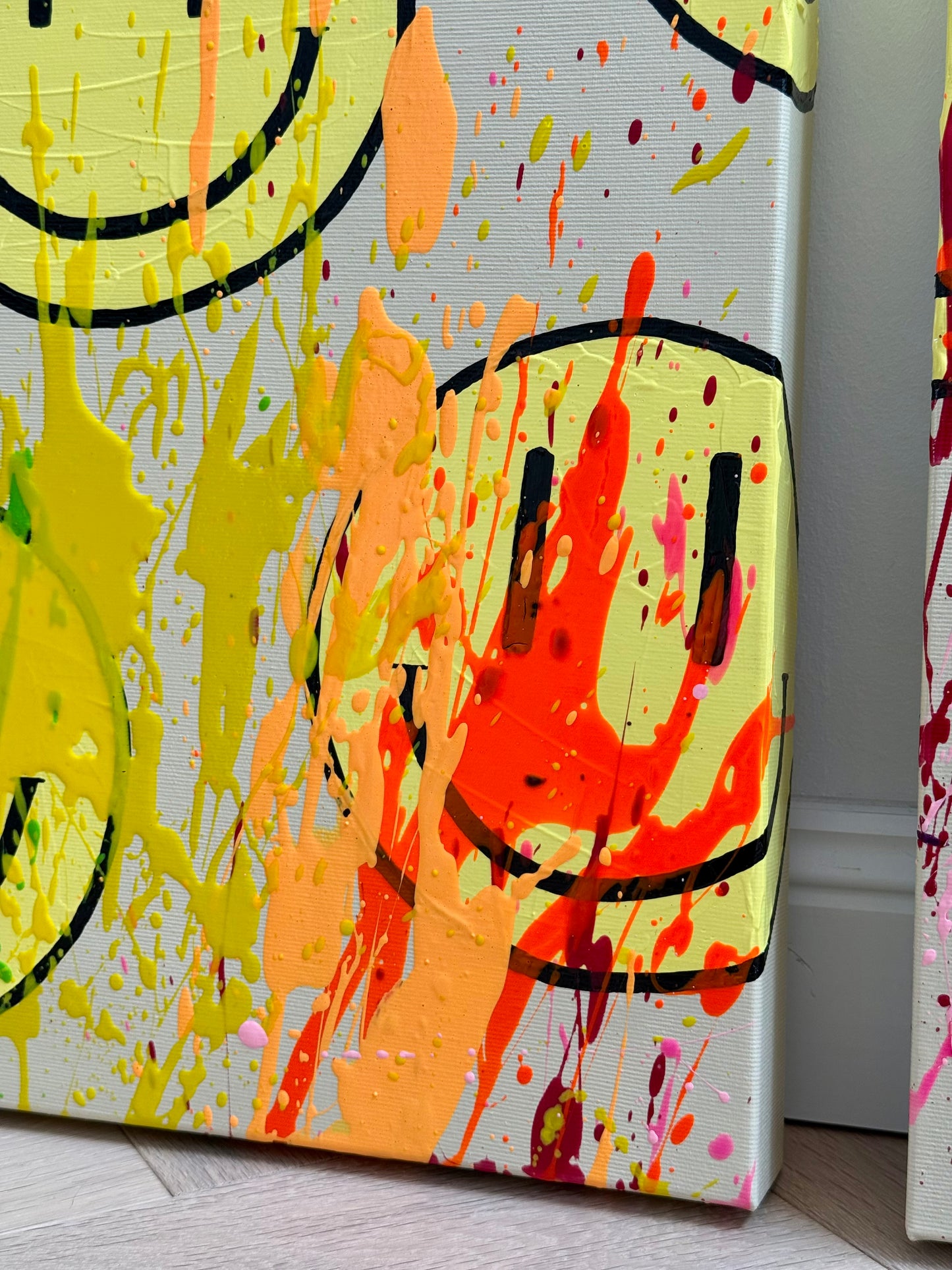 Detail von HAPPY #24 mit intensivem Neonorange, Apricot und Gelb sowie modernen Happy-Faces und strukturierter Acrylmalerei auf Leinwand.