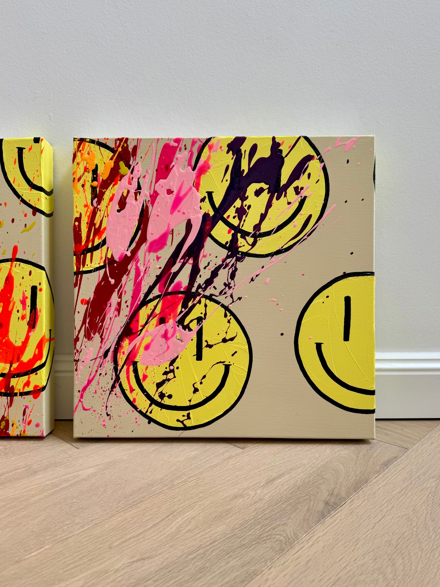 Detailansicht von HAPPY #25 mit kräftigen Pink-, Magenta- und Lilatönen, gelben Happy-Faces und dynamischen Farbspritzern auf Leinwand.