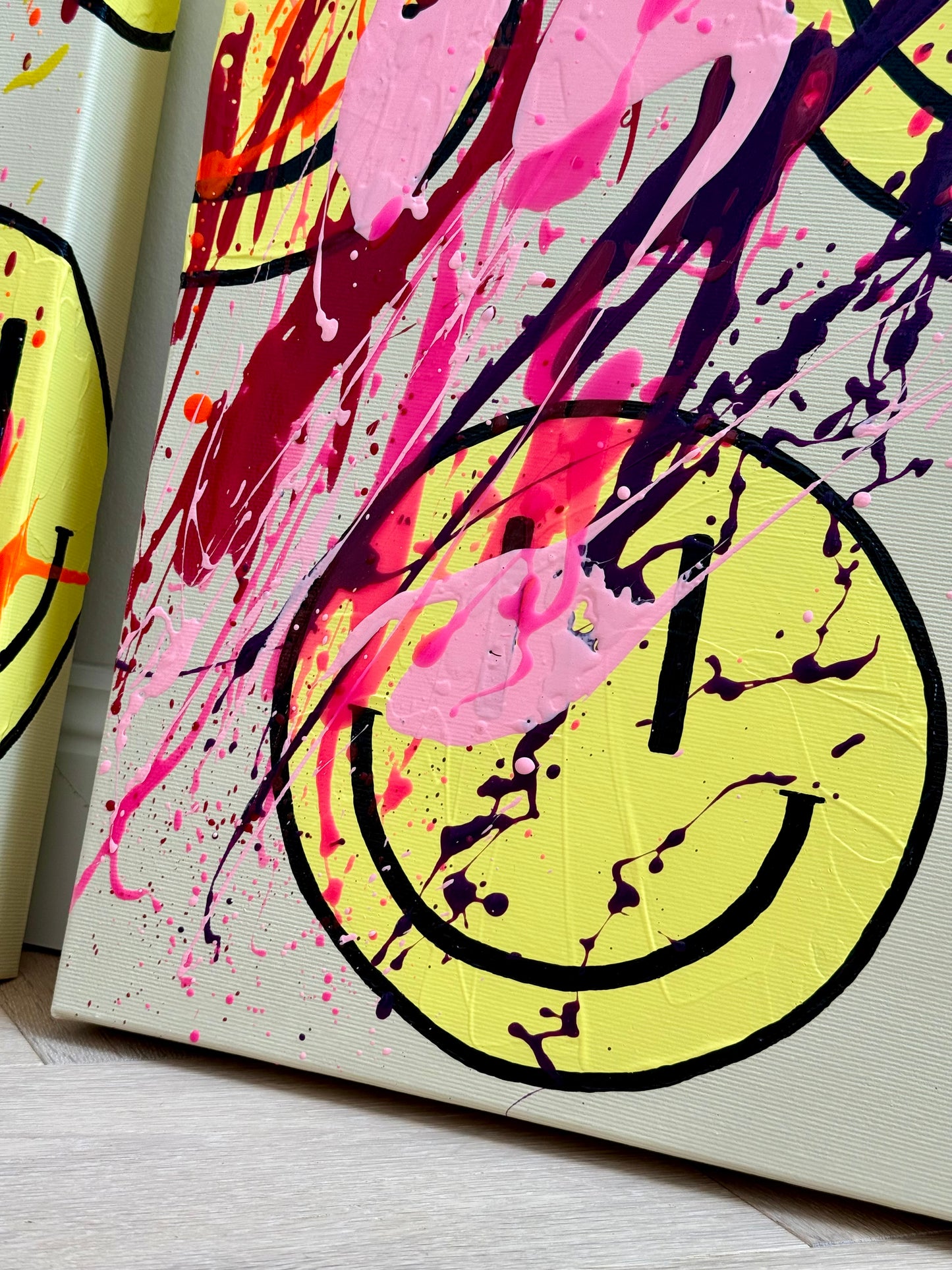 Makroaufnahme der Acrylstruktur von HAPPY #25 mit leuchtenden Pink- und Lilatönen sowie expressiven Farbspritzern auf einem Happy-Face-Motiv.